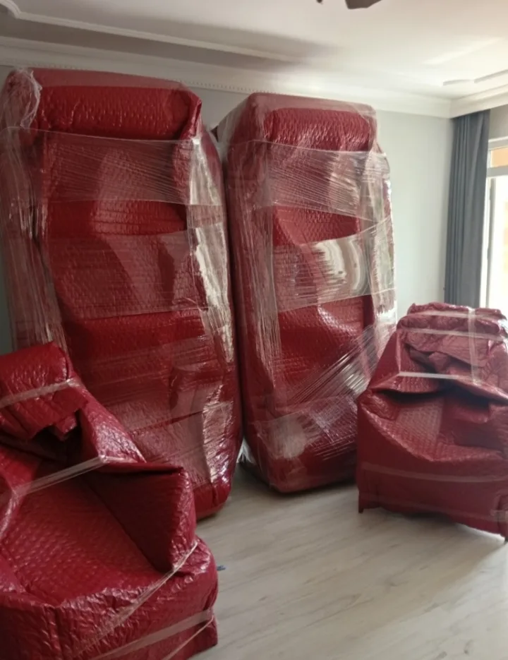 Kırmızı baloncuklu naylonla paketlenip ayakta duran koltuklar