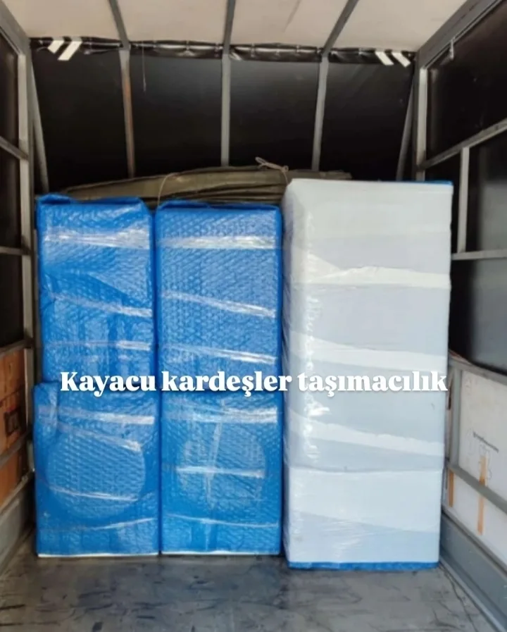 Mavi ve beyaz naylonla paketlenmiş eşyaların kamyon yüklemesi